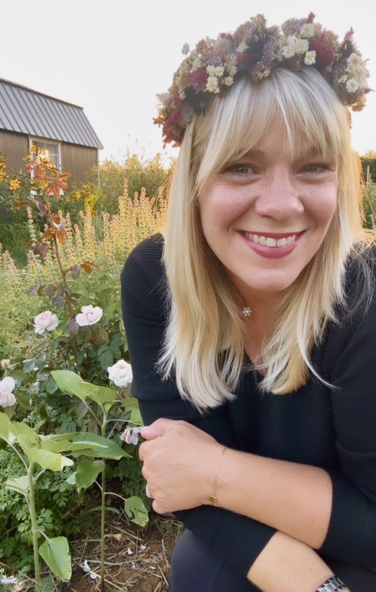 Kara Jamison smiling in the garden wearing a dried flower crown